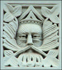 On the first storey faade between shop frontages on Percy Street, Hanley - there are two panels depicting Green-Man type faces