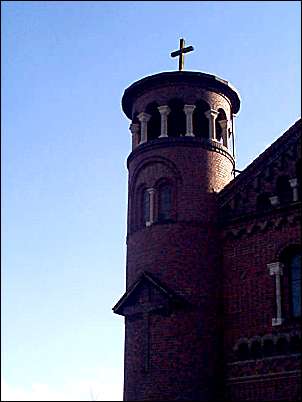 round southwest tower with conical roof over open arcade