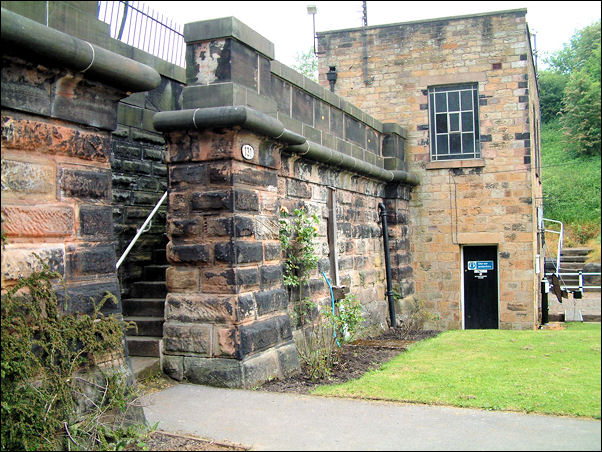 gap with flanking pilaster buttresses leading to pairs of long flights of steps rising between the walls