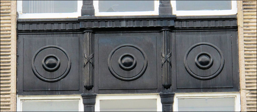 paneling with geometric patterns above the ground floor windows  