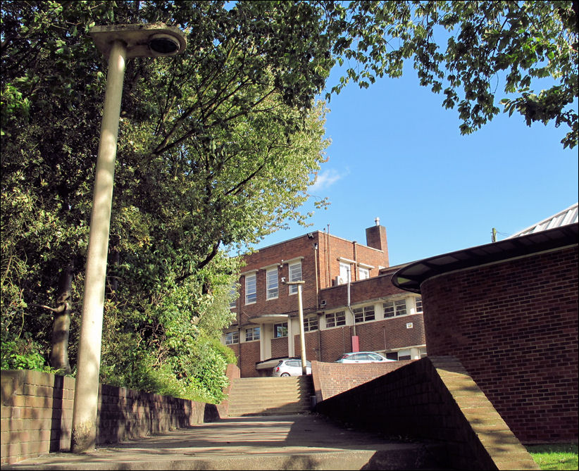 concrete art deco lamposts line the path leading to the art deco school at the top