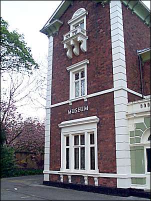 the main faade with various architectural features including a stone balcony under the window on the first floor